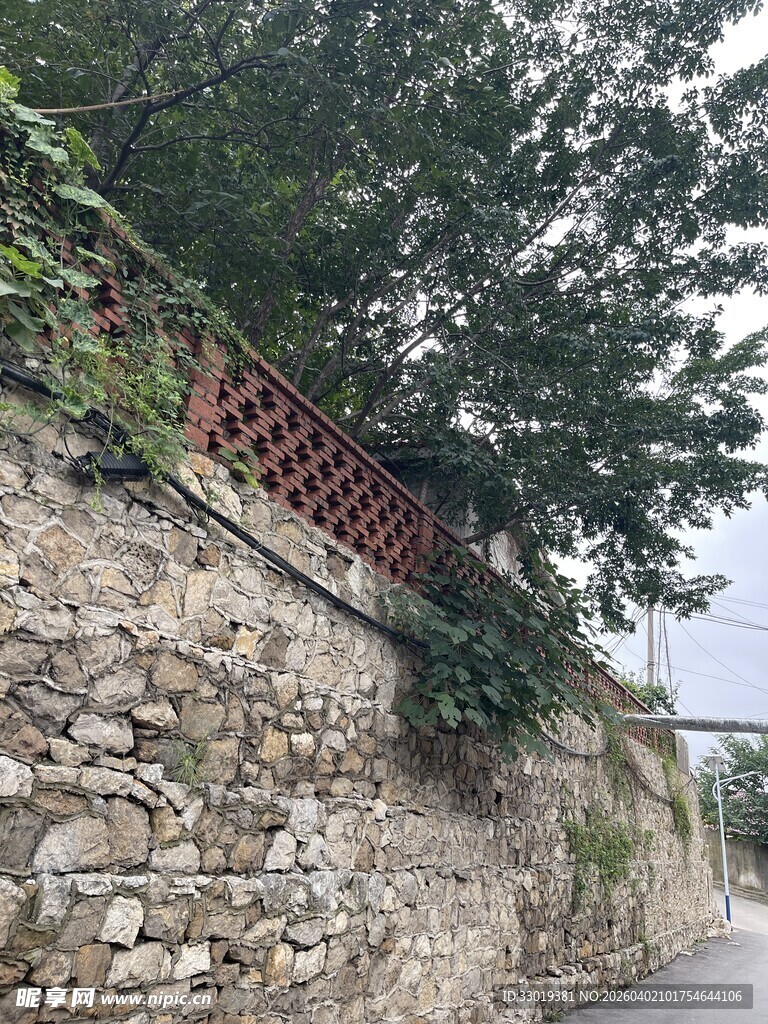 石墙边的绿植与红栏杆