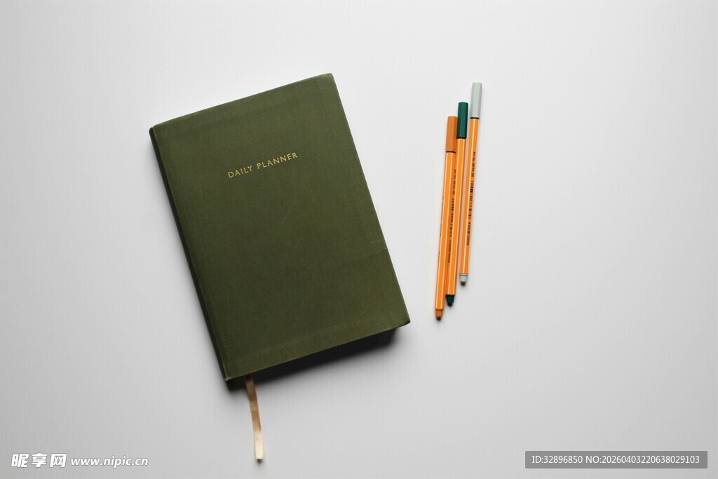 绿色笔记本与橙色铅笔