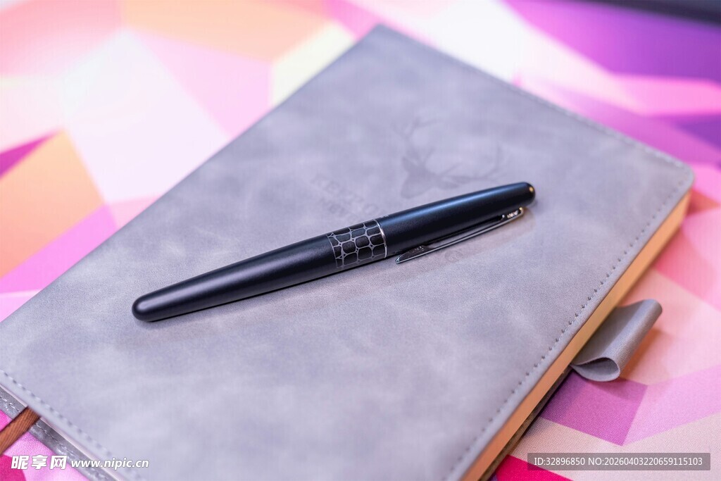 精致钢笔置于笔记本上