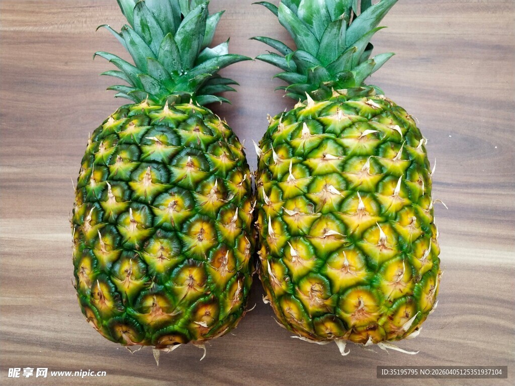 两个新鲜菠萝摆放在木面