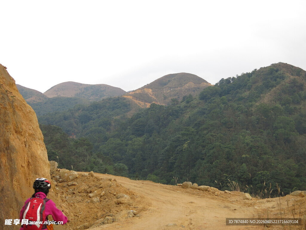 女子骑行于山间土路