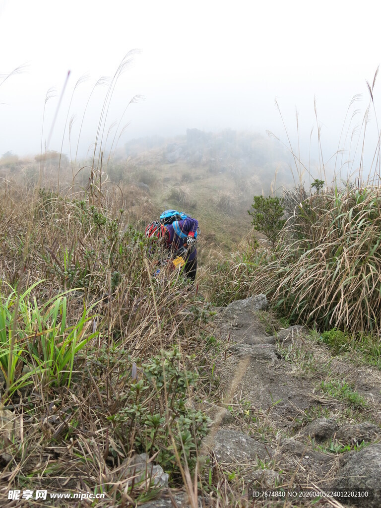 徒步者穿行于山间迷雾中