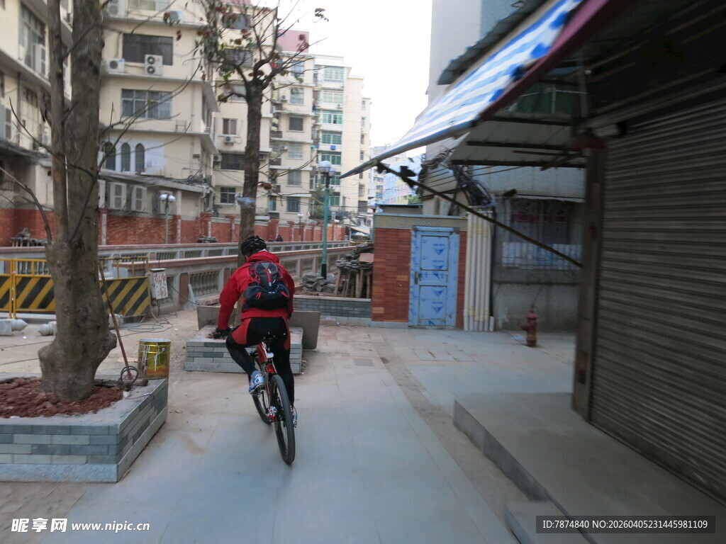 男子骑行于城市小巷