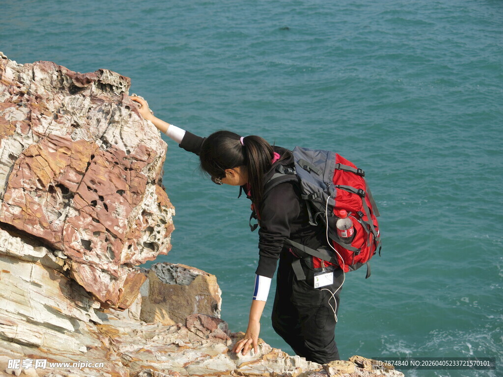 女子崖边专注观察海景