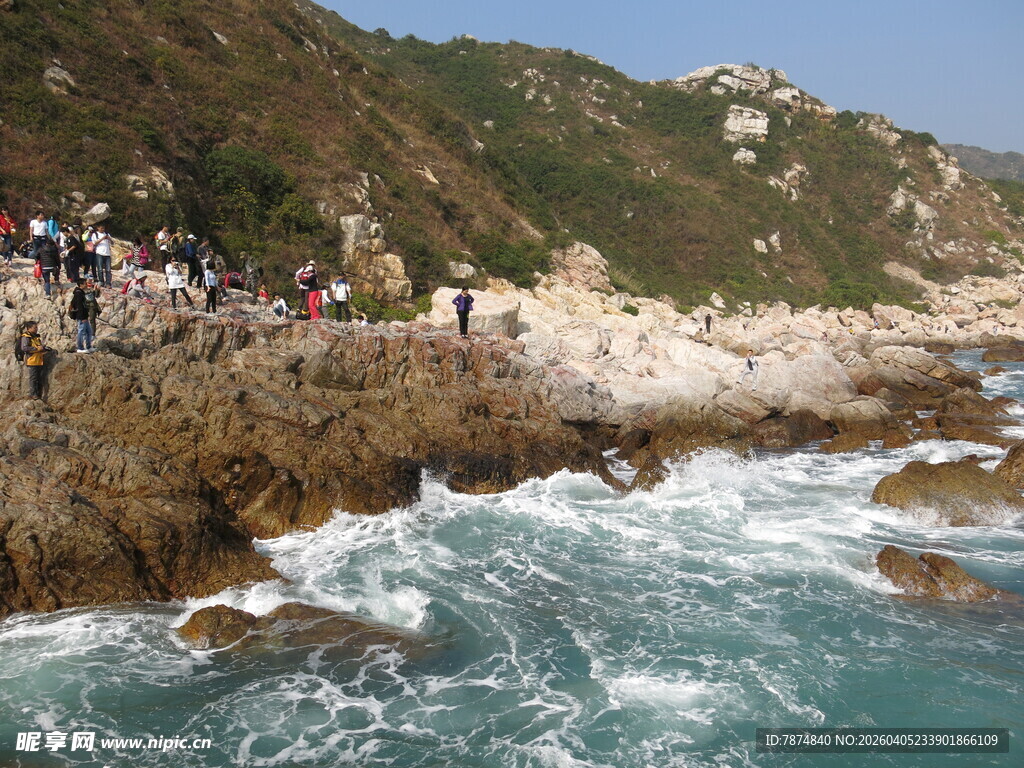 海岸边人群赏汹涌海浪