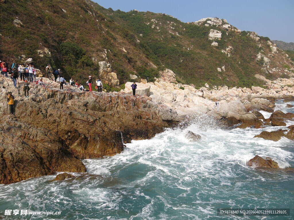 海边岩石处游人观浪景象