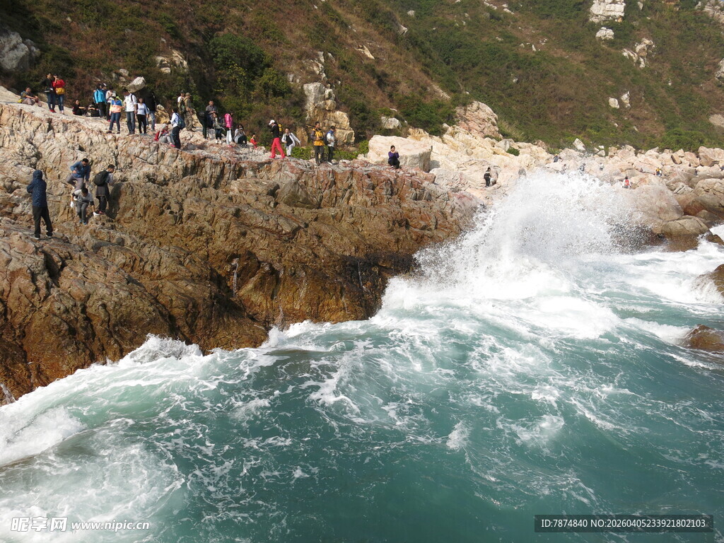 海边礁石处的观浪人群