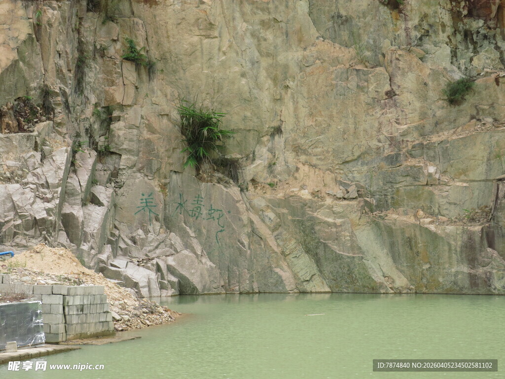 山间绿水旁的陡峭岩壁