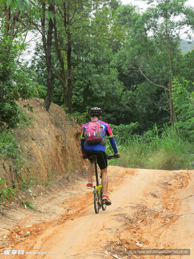 骑行者穿梭于山林土路