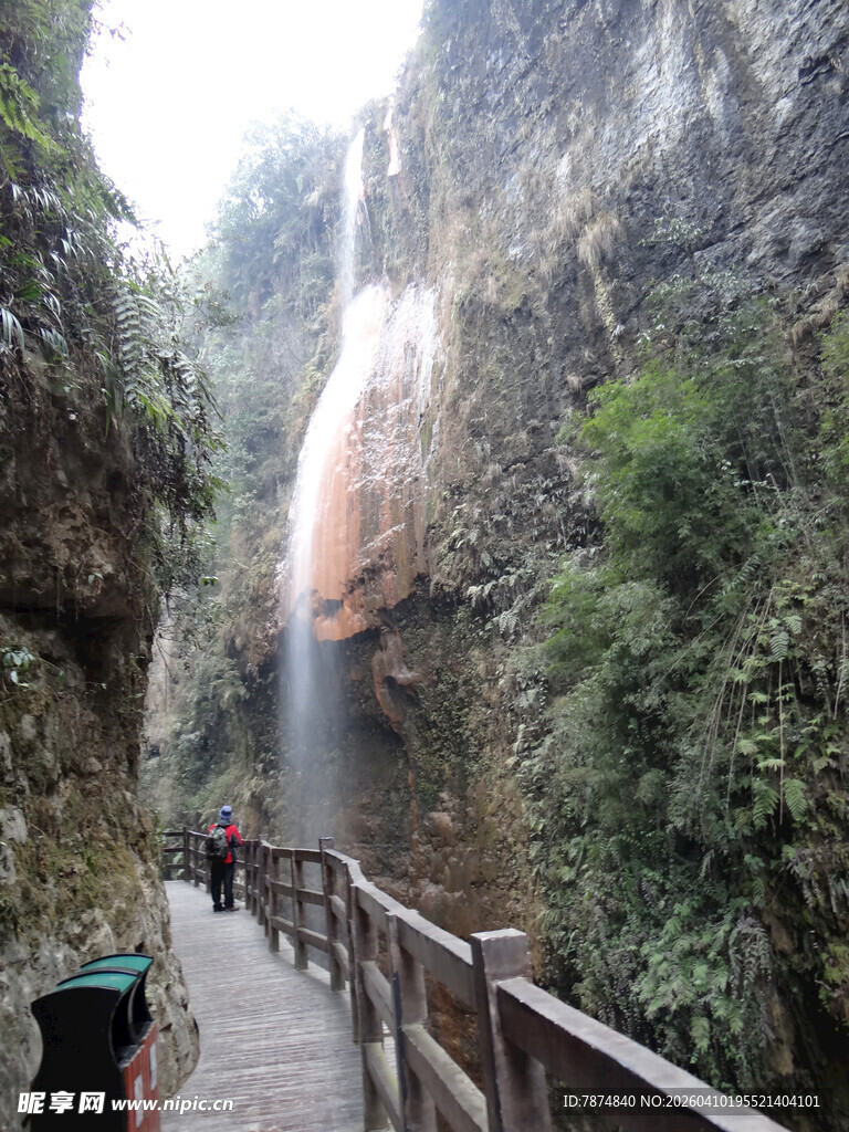 恩施山间栈道旁的壮丽瀑布