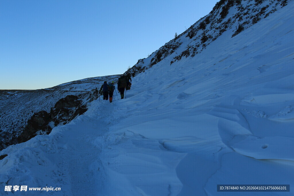 雪地登山者攀登陡峭山坡