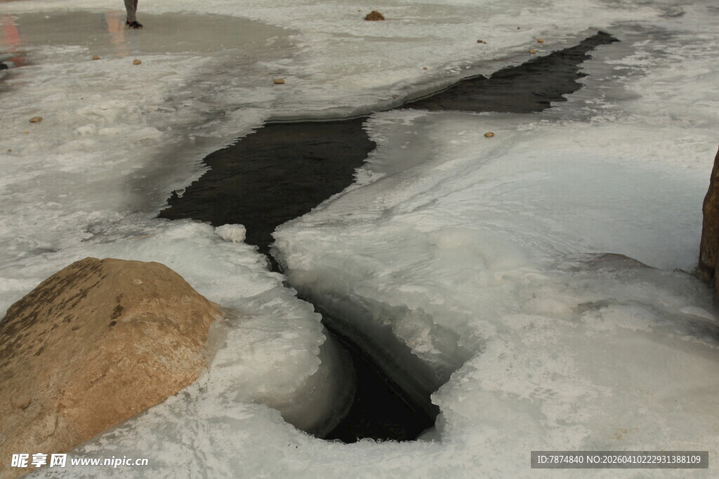 冬日冰面裂缝与石块景象