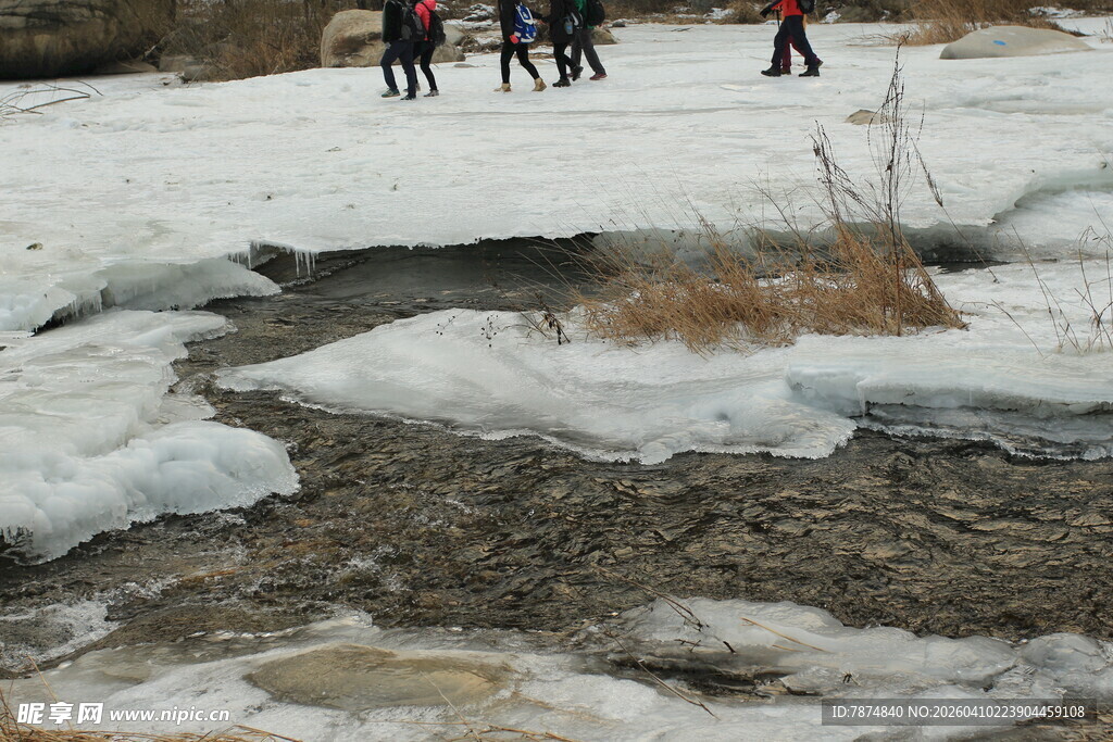 雪地徒步者旁的融冰小溪
