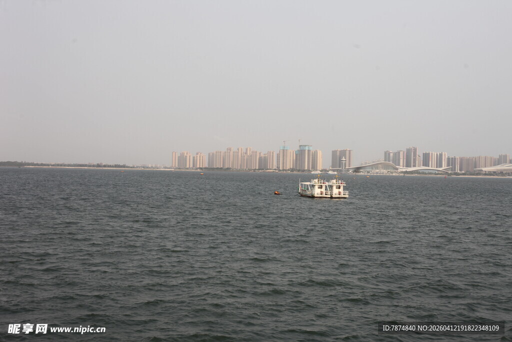 湛江海上孤舟与远处城市景观