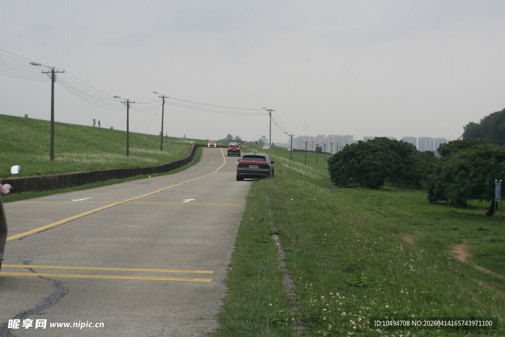 穿过绿色草地行驶的车辆与风景