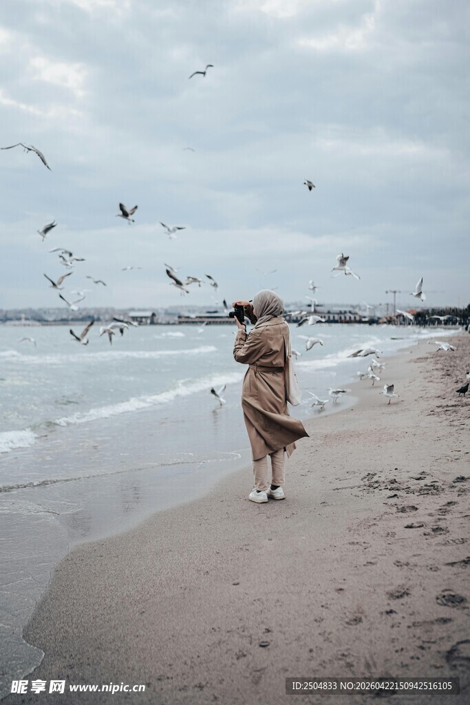 女子海边漫步与飞鸟相伴