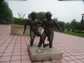 两个小孩玩足球雕塑