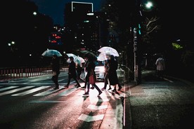 雨夜撑伞过人行道的行人