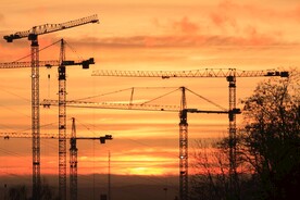 夕阳余晖中的建筑工地塔吊剪影