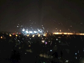 夜晚玻璃上的雨水和远处灯光光晕