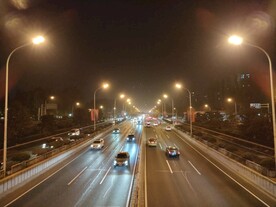北京秋天夜晚行驶的车辆和路灯