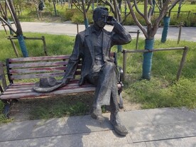 公园座椅拿帽子人物雕塑
