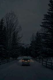 夜幕下在雪道行驶的汽车