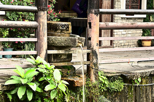 深圳甘坑古镇角落的石磨与流水