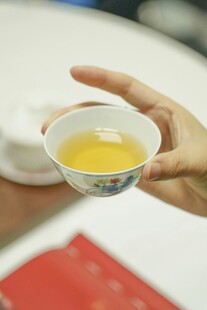手持茶杯品茗韵