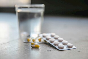 水杯旁的药片与胶囊