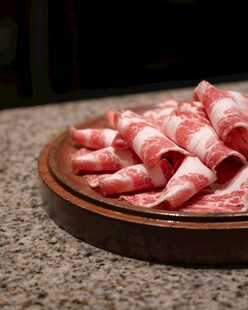 新鲜牛肉卷摆放在盘中