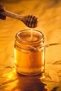 蜂蜜正缓缓倒入玻璃罐中