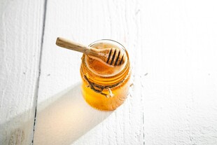 罐中蜂蜜与木质搅拌棒