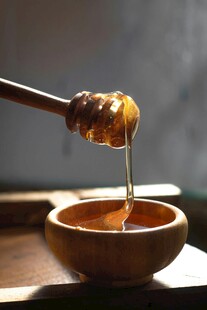 蜂蜜从木勺滴入木碗中
