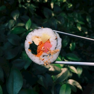 筷子夹起美味寿司卷