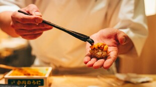 手用筷子夹取美味食物