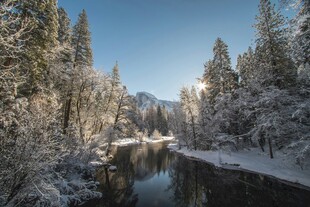 冬日雪覆山林中的静谧河流