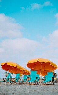 海边橙色遮阳伞与躺椅