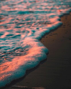 夕阳下的海浪拍打沙滩