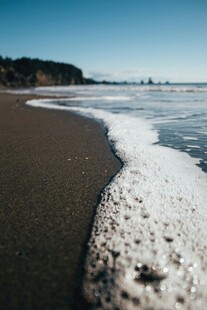 海边浪花拍打黑色沙滩
