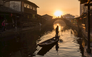 夕阳下的水乡撑船景象