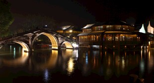 夜晚河畔拱桥的璀璨景致