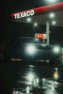 夜晚加油站前的亮灯汽车