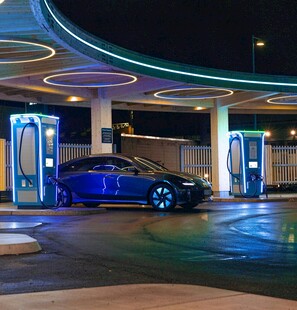 夜间充电站中的蓝色电动汽车