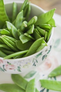 碗中鲜嫩的翠绿豌豆荚