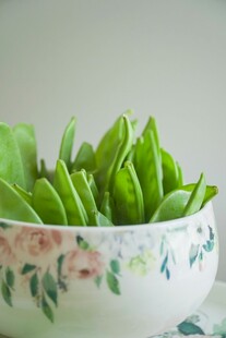 瓷碗中的鲜嫩豌豆荚