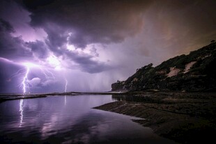 闪电划破夜空下的水面