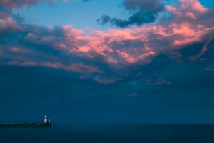 海上暮色中的孤船与彩云