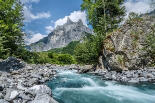 山间溪流旁的壮丽山峰
