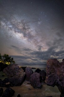 海边夜空下的岩石与星云